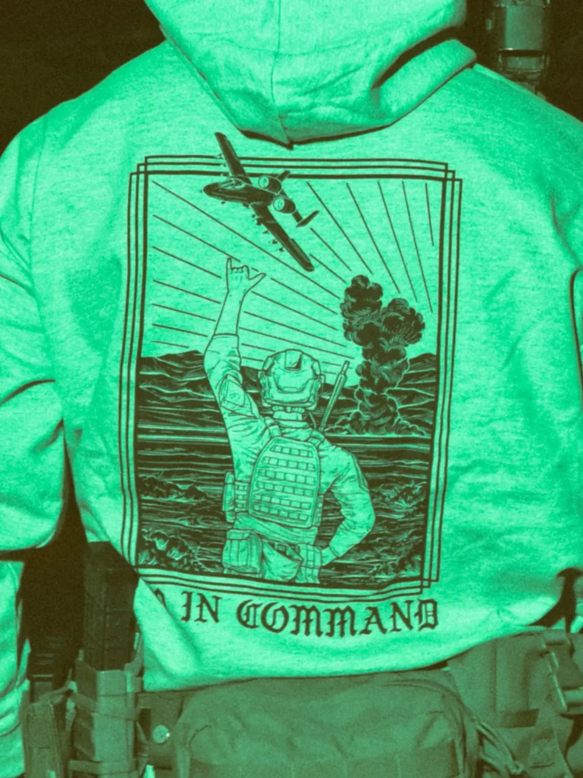 the trace apparel collection featuring a fst jtac guy standing in front of a firing plane