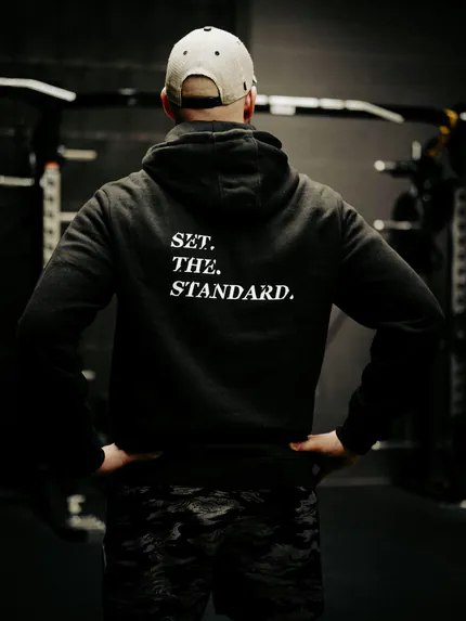 Black hoodie from The Trace featuring Set the Standard design symbolizing the pursuit of the highest performance