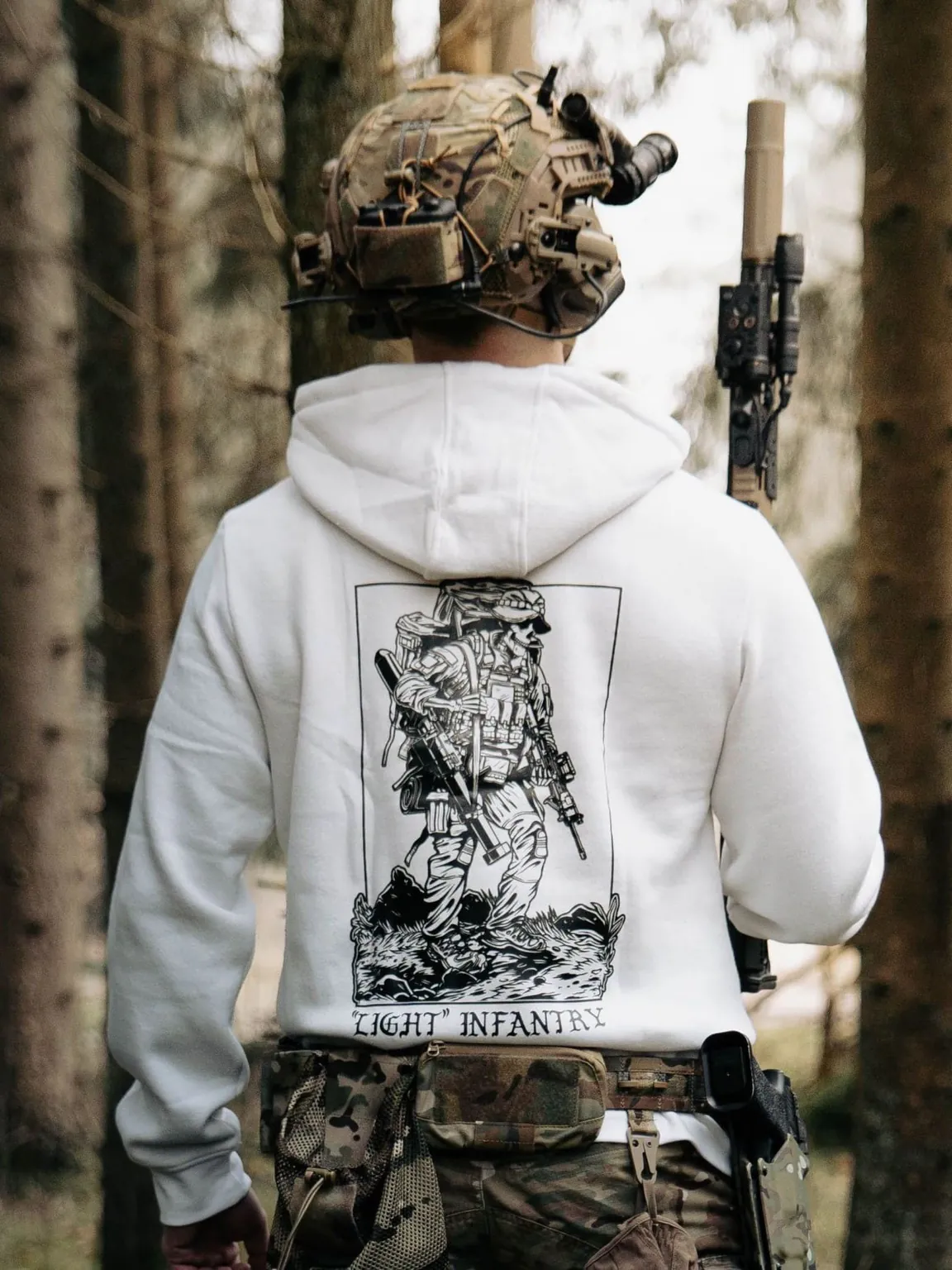 white hoodie from The Trace depicting Light Infantry design with a soldier standing with a heavy backpack