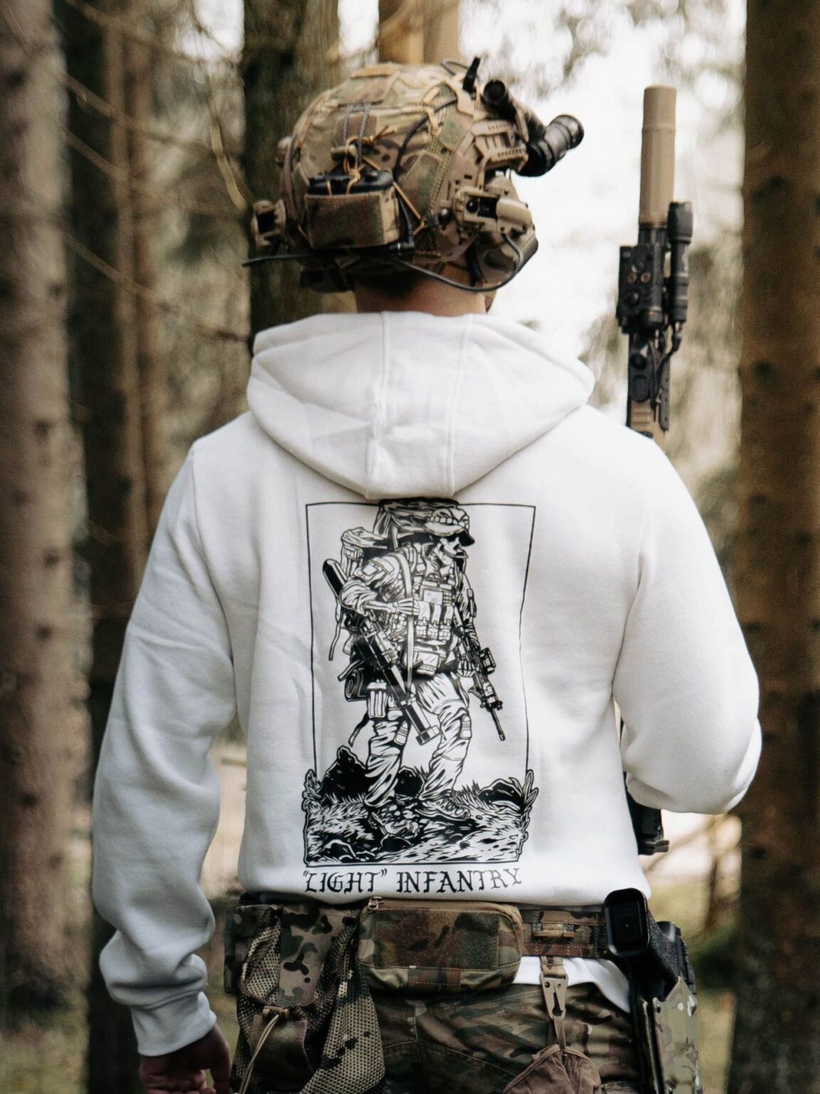 Hoodie blanc de The Trace avec le design Light Infantry représentant un soldat portant un sac à dos lourd