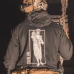 black hoodie featuring a girl carrying an anti tank weapon.