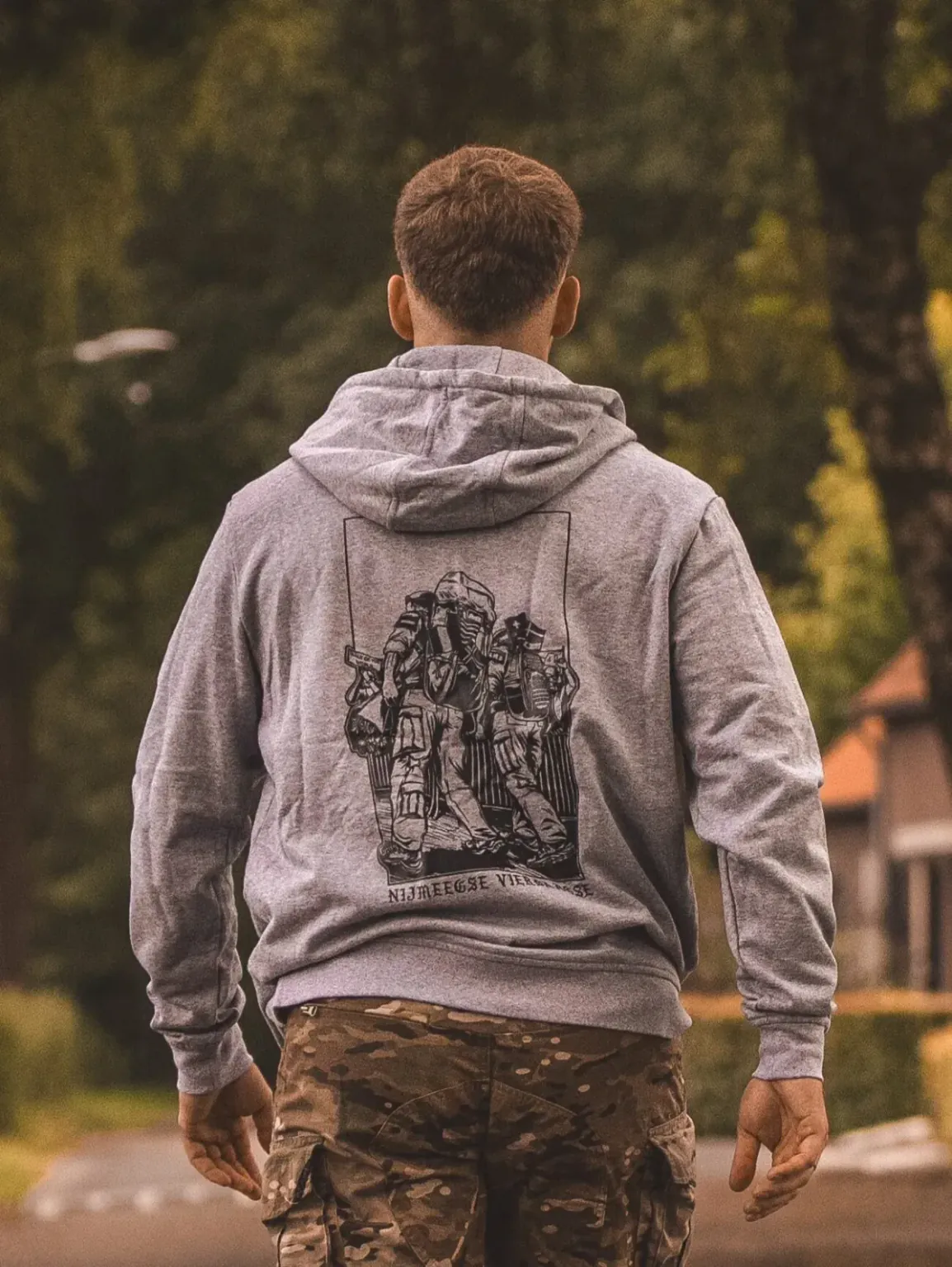 20240707_123636-e1753362996505 heather grey hoodie from The Trace featuring design of two soldiers marching in the Nijmegen Four Days Marches