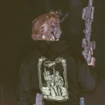 the trace apparel collection featuring 2 air assault operators standing in front of a chinook