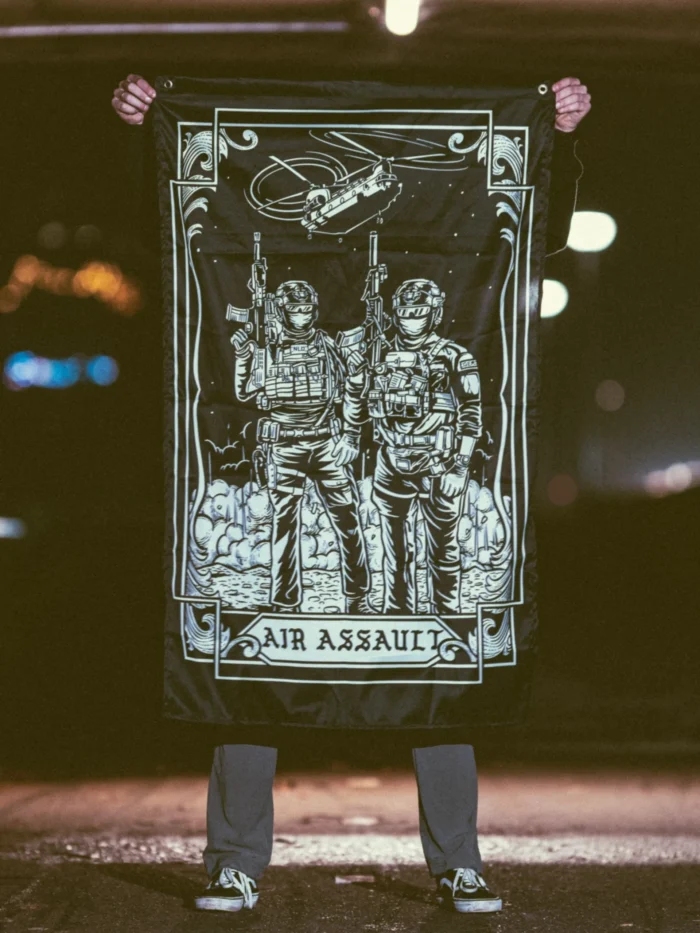 the trace apparel collection featuring 2 air assault operators standing in front of a chinook