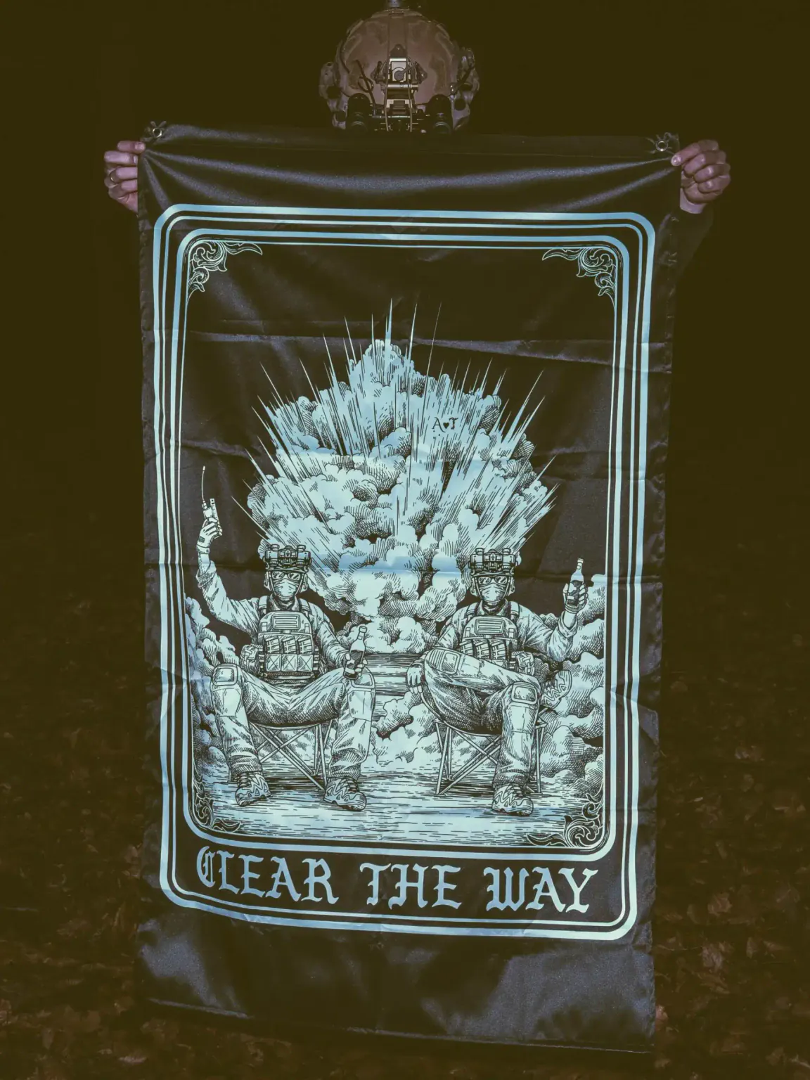 Clear-the-way-flag the trace apparel collection with 2 guys sitting in front of a explosing because they are part of the eod