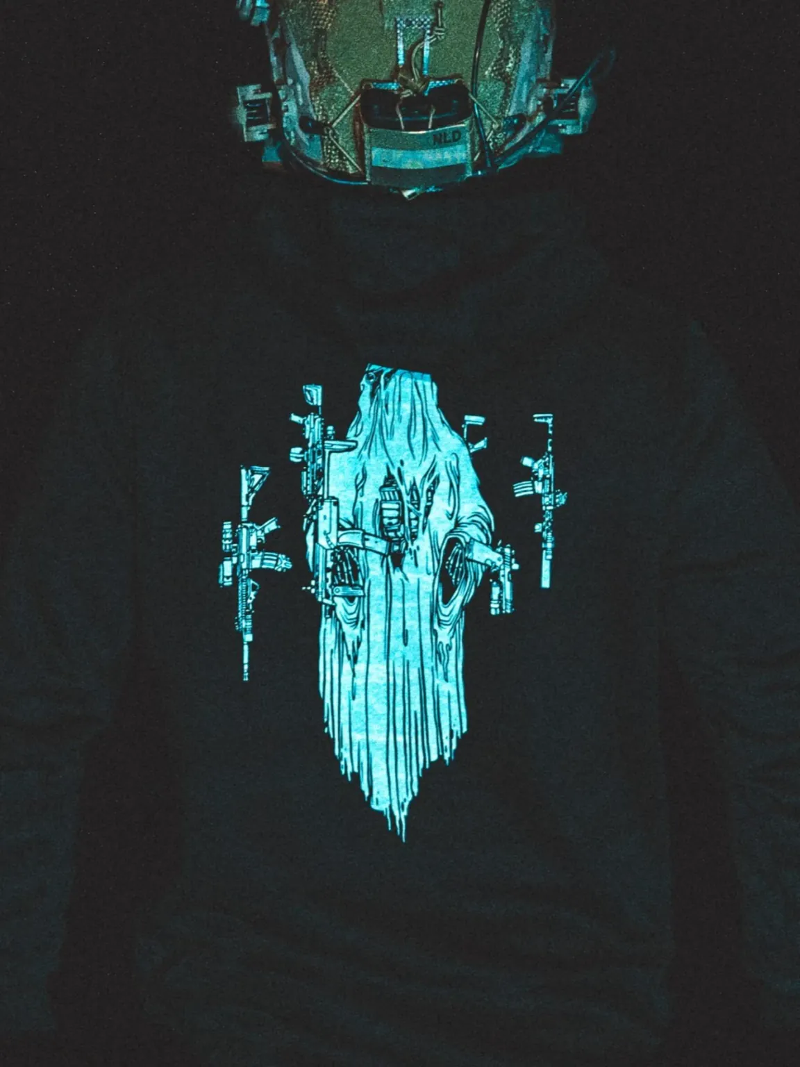 Halloween Ghost Hoodie by The Trace, close-up shot at night under blue light, the real print is white
