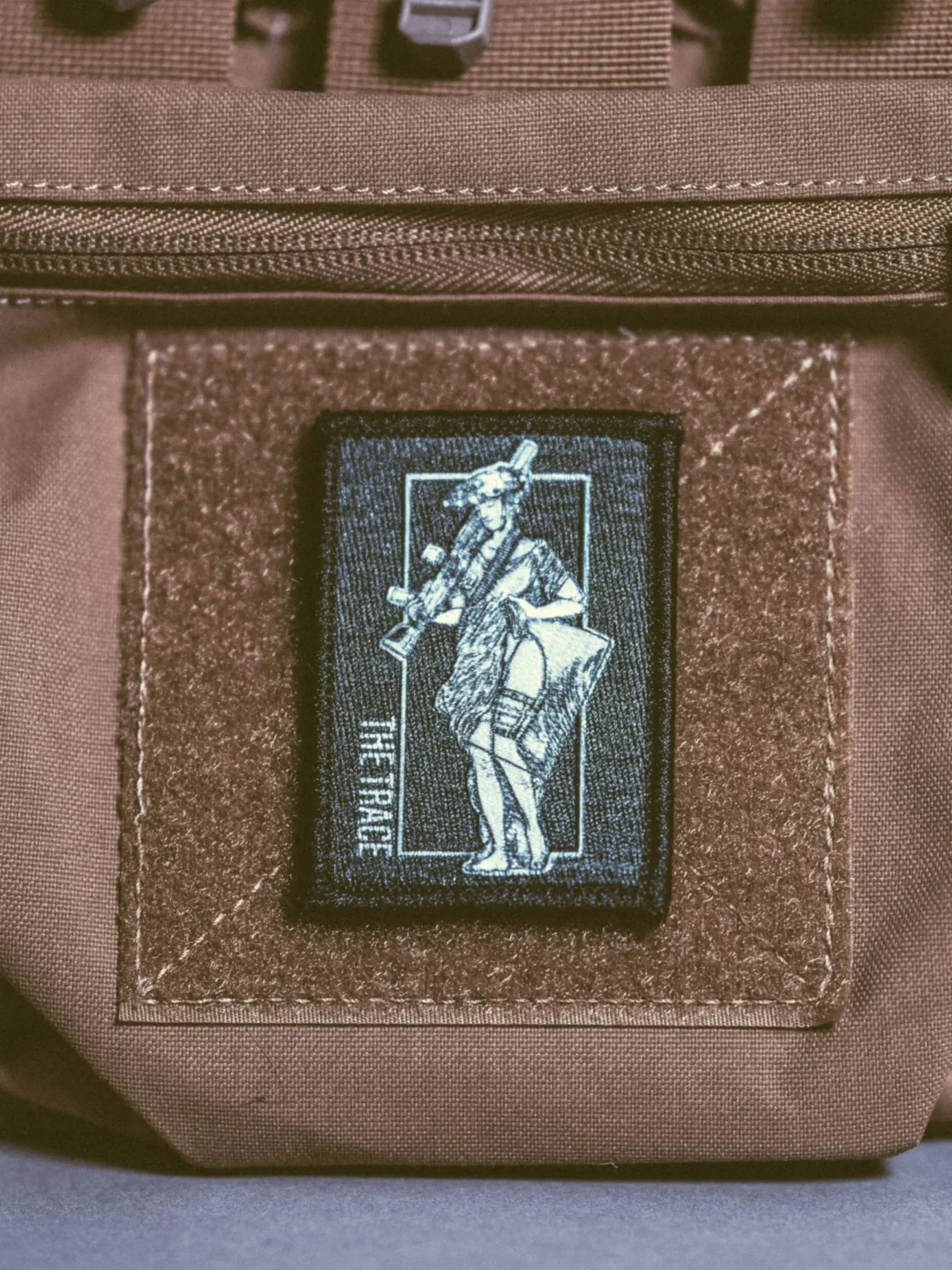 Lmg-statue-patch-edit_1 the trace apparel collection patch featuring a woman holding a machine gun