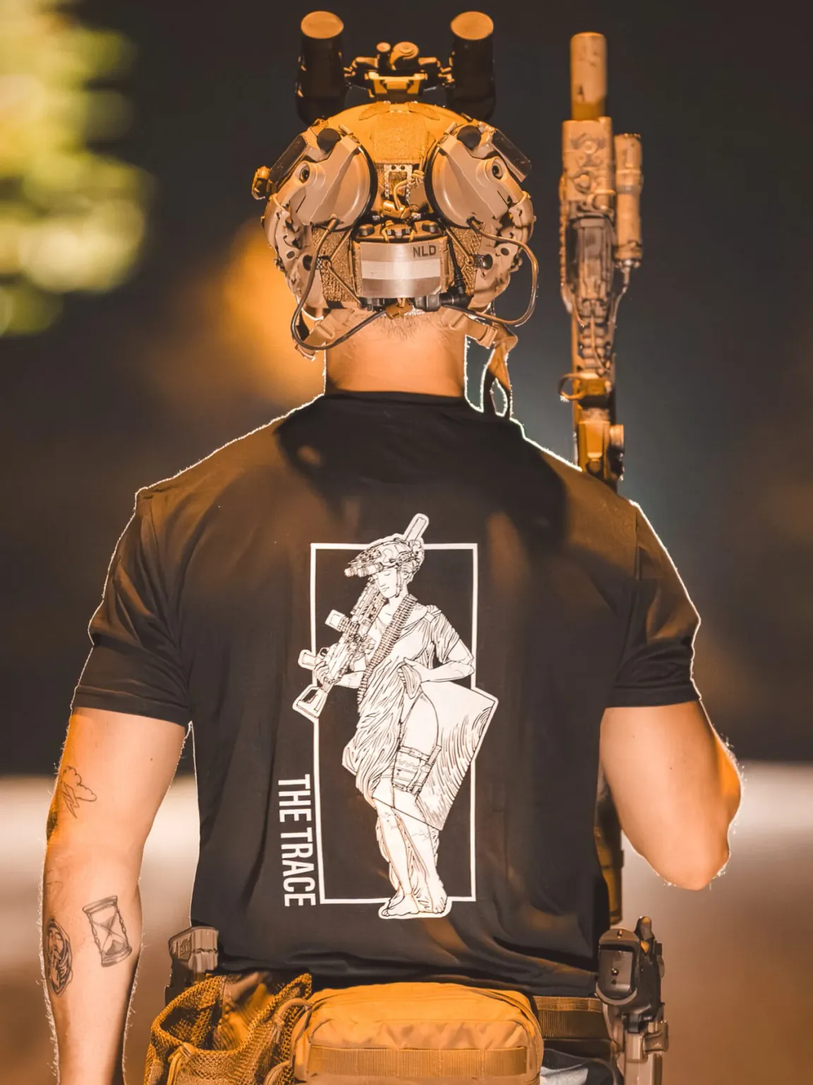Lmg-statue-shirt black shirt from The Trace featuring a girl carrying a machinegun