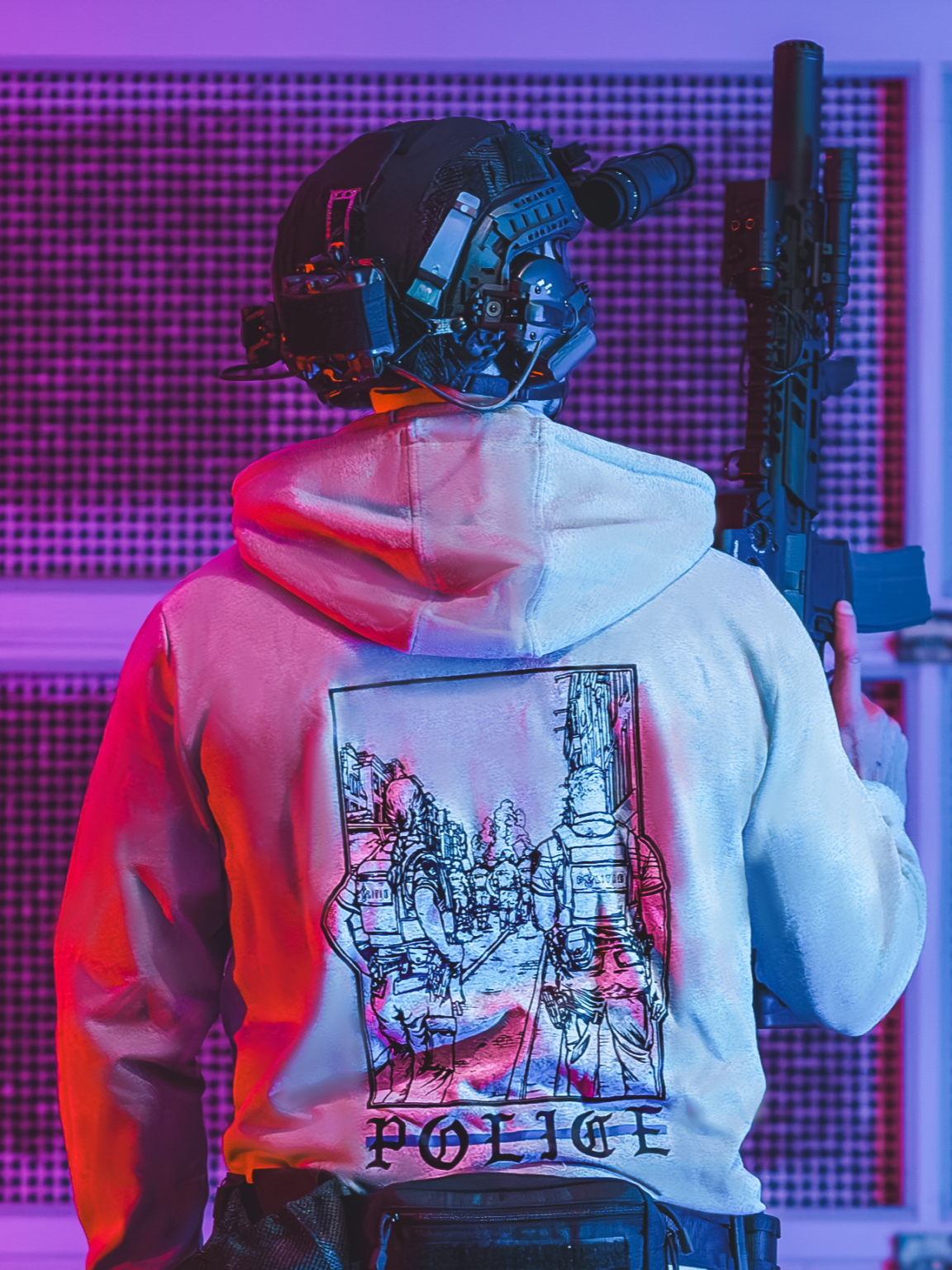 Police-hoodie-heather-grey collezione di abbigliamento The Trace con due poliziotti in piedi in una strada mentre osservano una sommossa