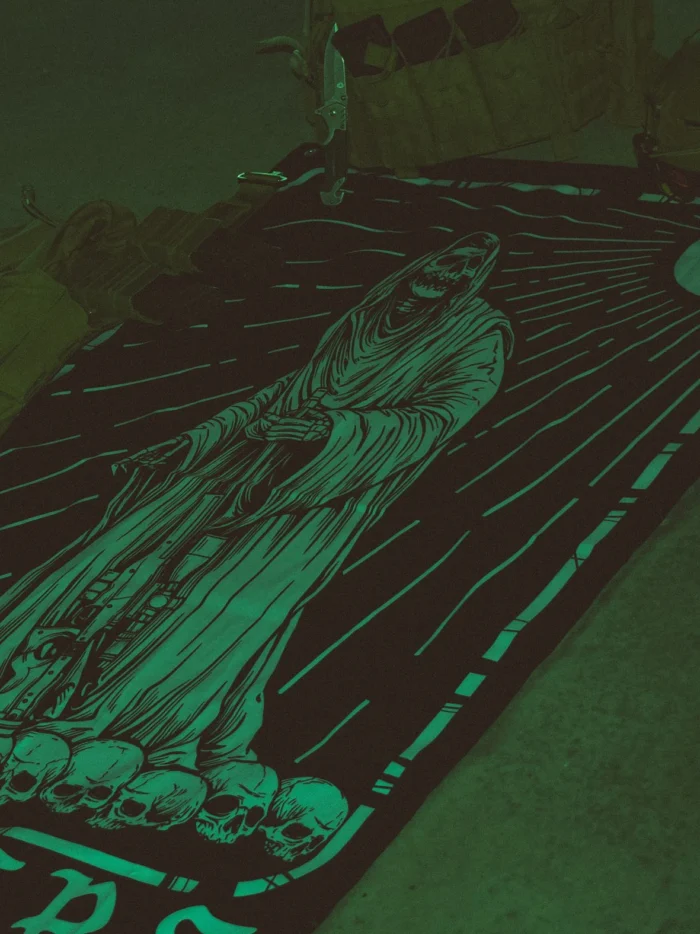 Combat flag displaying a sniper skeleton atop skulls, gripping an Arctic Warfare Super Magnum in a bold, battlefield stance.