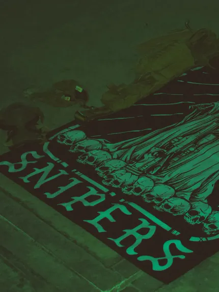 Combat flag displaying a sniper skeleton atop skulls, gripping an Arctic Warfare Super Magnum in a bold, battlefield stance.