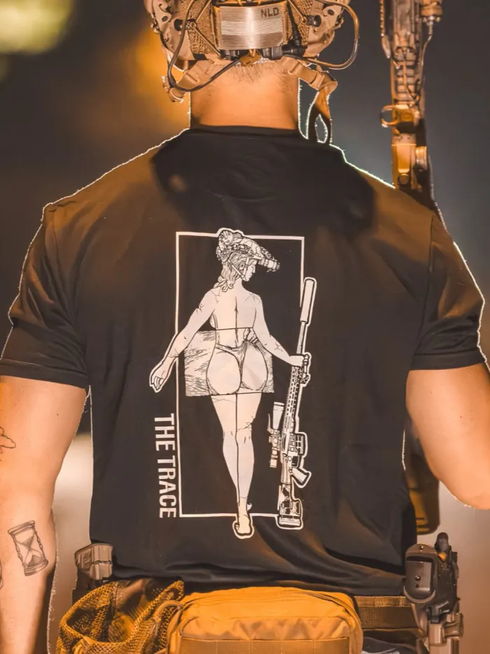 black tshirt from The Trace featuring a girl carrying a sniper weapon.