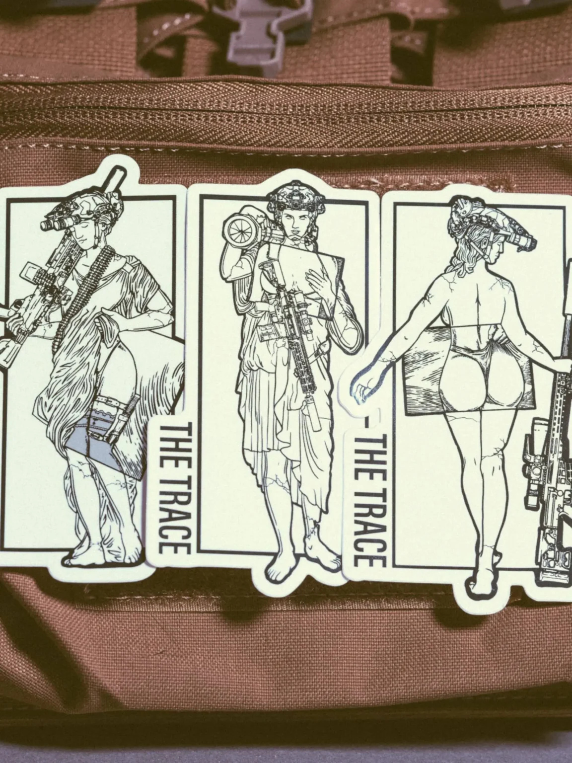 the trace apparel collection sticker featuring a woman holding a anti tank weapon machine gun and sniper