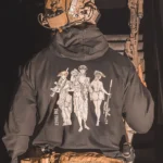 black hoodie from The Trace featuring 3 girls carrying a machinegun sniperrifle and anti tank weapon