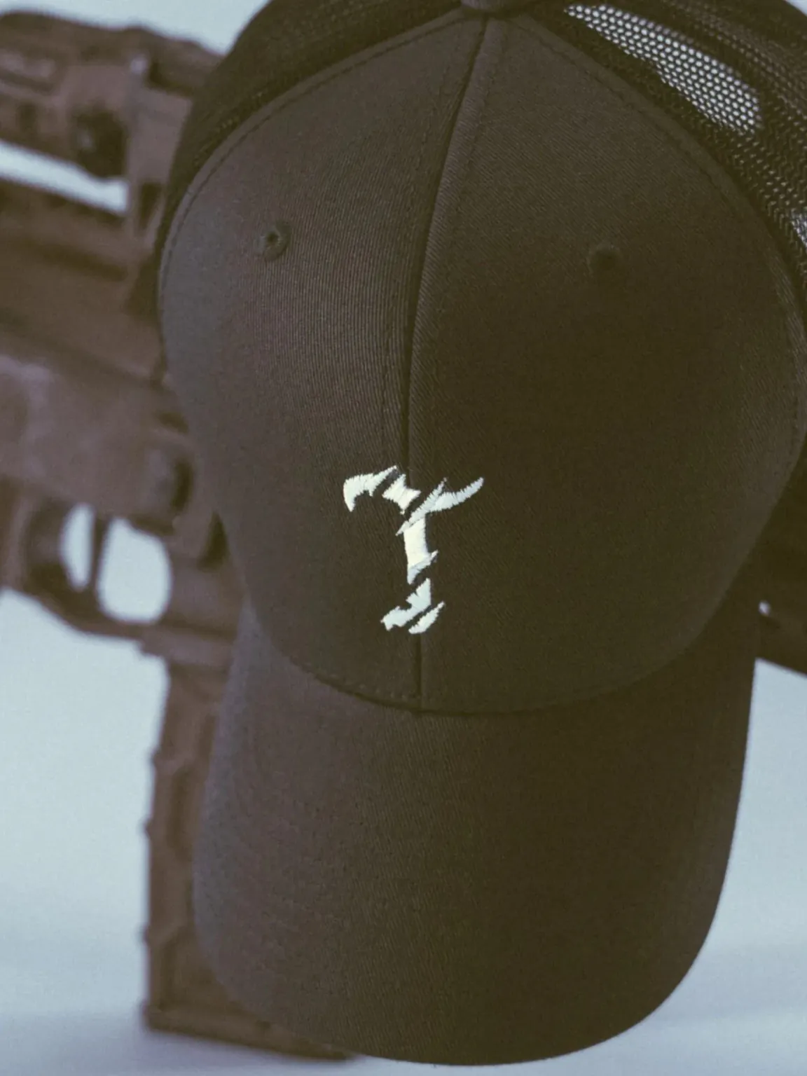 black charcoal cap with the T logo from The Trace
