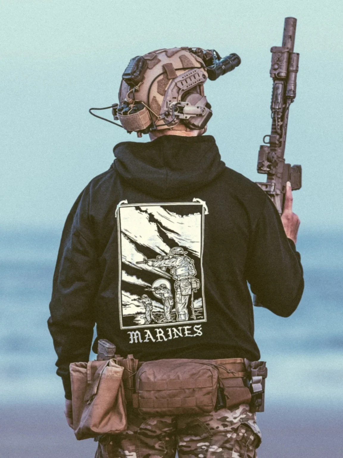 marines-hoodie-black-_2_ collezione di abbigliamento The Trace con dei marines in piedi, in parte immersi nell'acqua