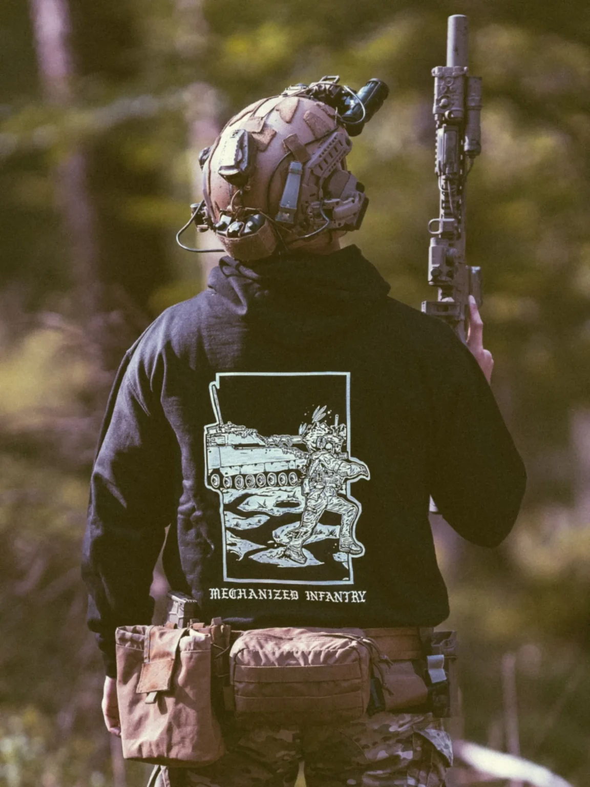 Collection de vêtements The Trace avec des hommes combattant aux côtés d'un véhicule militaire CV90