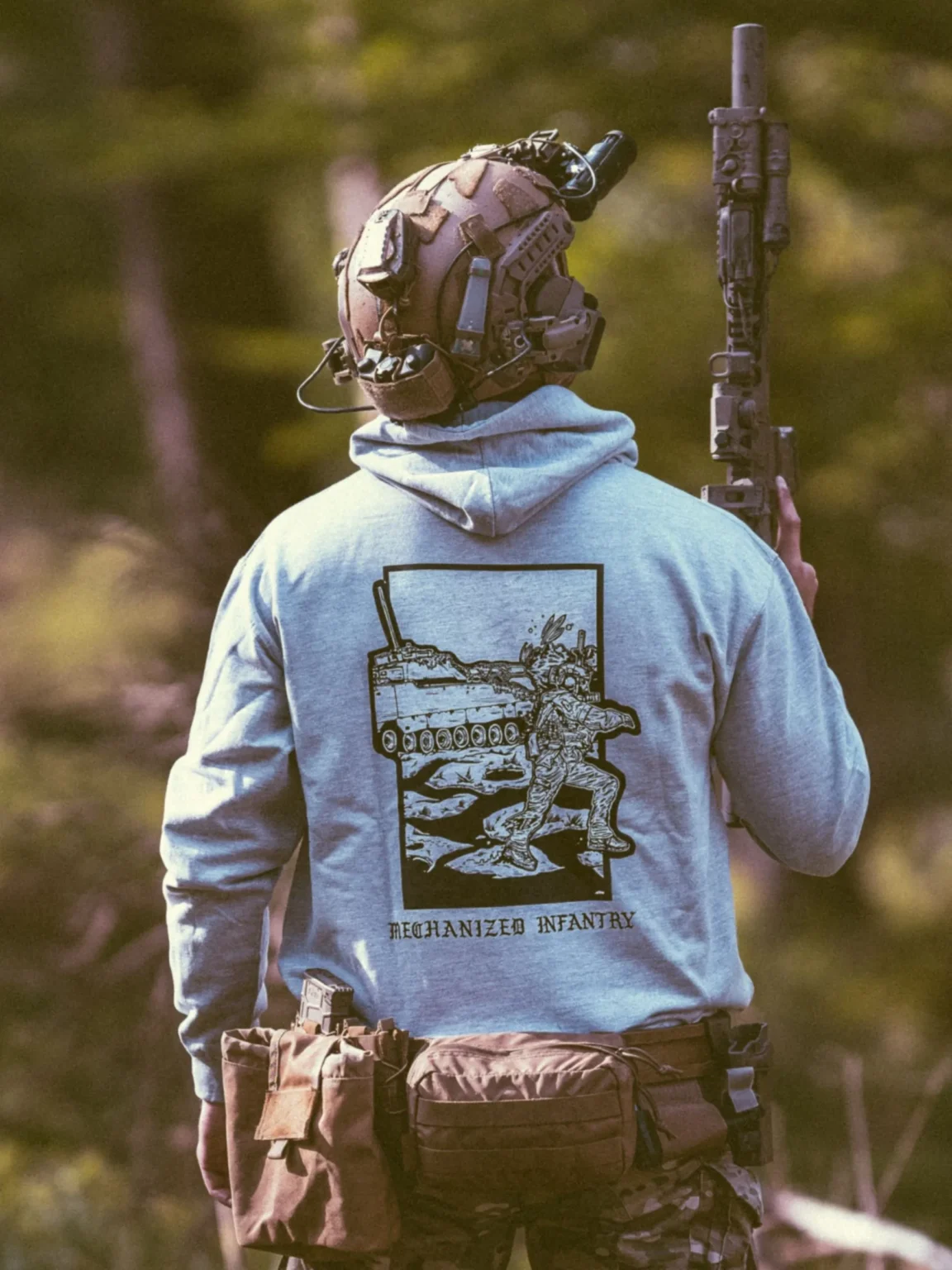 Collection de vêtements The Trace avec des hommes combattant aux côtés d'un véhicule militaire CV90