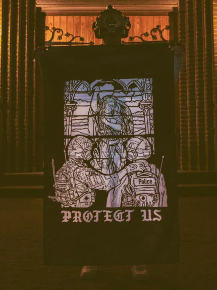 the trace apparel collection featuring a military and a police guy standing in front of a tinted window that displays saint michael the protector