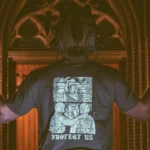 the trace apparel collection featuring a military and a police guy standing in front of a tinted window that displays saint michael the protector