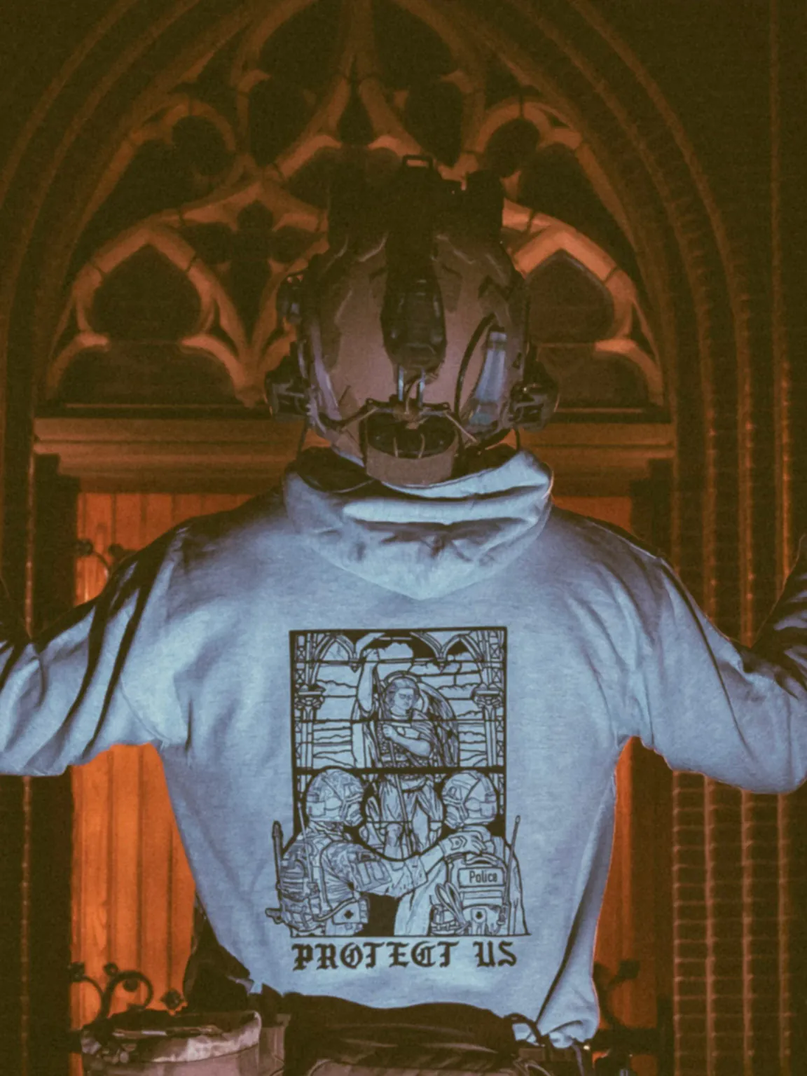mog-x-trace-heather-grey-hoodie-back the trace apparel collection featuring a military and a police guy standing in front of a tinted window that displays saint michael the protector