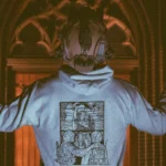 the trace apparel collection featuring a military and a police guy standing in front of a tinted window that displays saint michael the protector