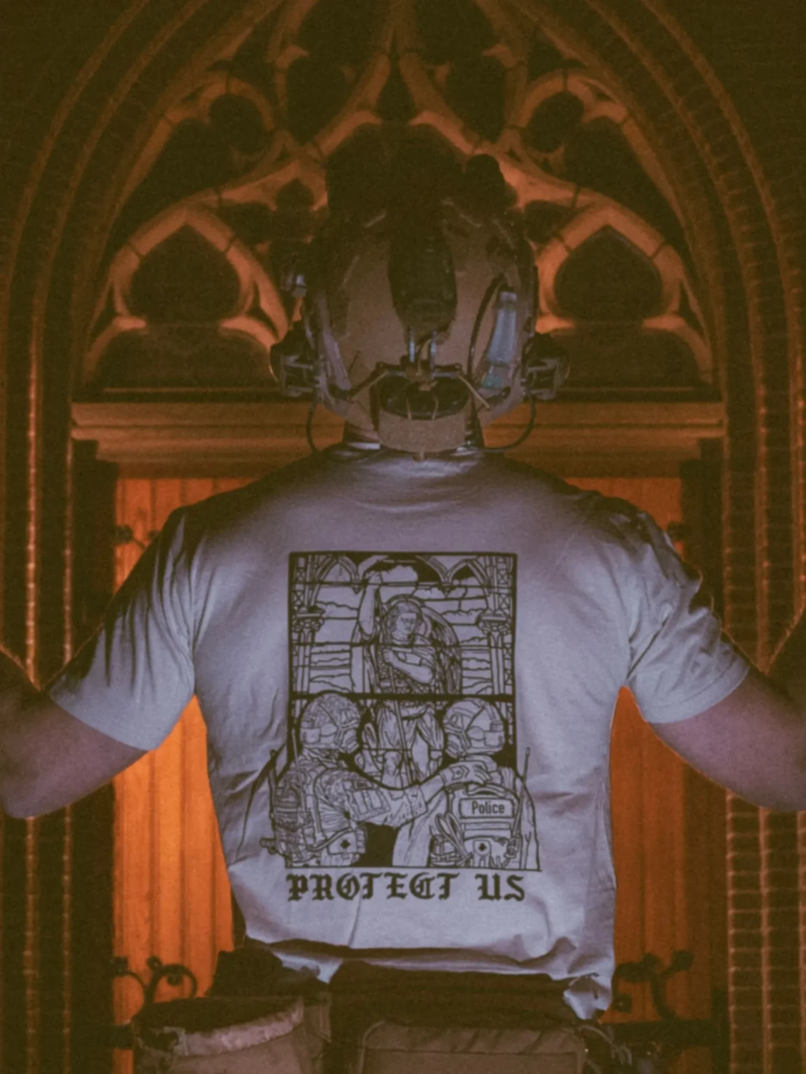 mog-x-trace-sand-back the trace apparel collection featuring a military and a police guy standing in front of a tinted window that displays saint michael the protector