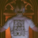 the trace apparel collection featuring a military and a police guy standing in front of a tinted window that displays saint michael the protector