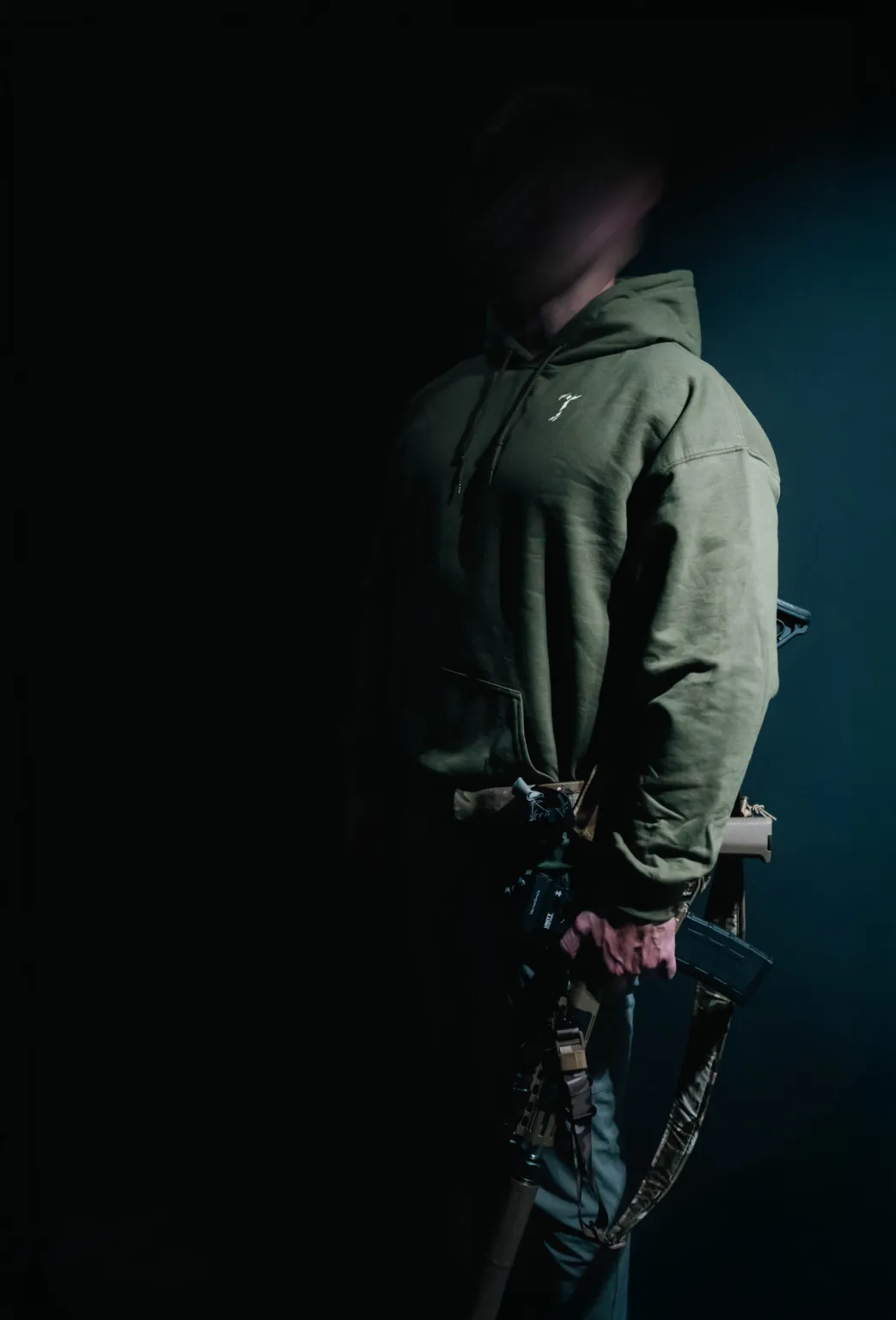 Military green hoodie by The Trace on a model, seen from the front side with the small T logo on the chest