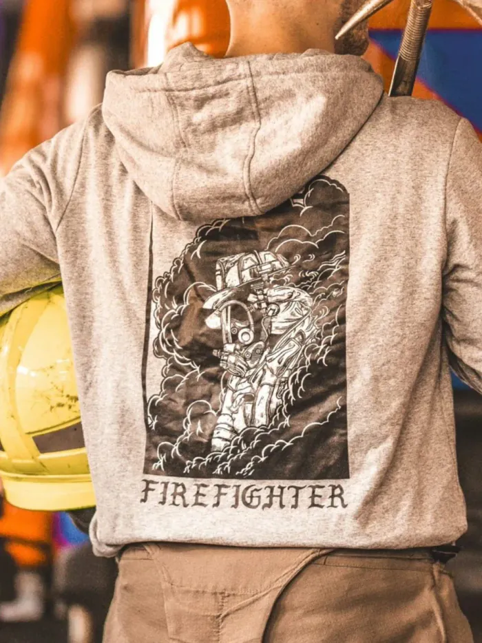 the trace hoodie featuring a firefighter standing in front of a firetruck