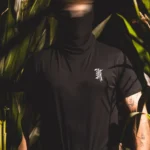 Halloween Skeleton Logo T-shirt in black by The Trace, chest print of a skeleton hand holding the T logo