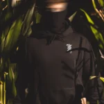 Halloween Skeleton Logo hoodie in black by The Trace, chest print of a skeleton hand holding the T logo