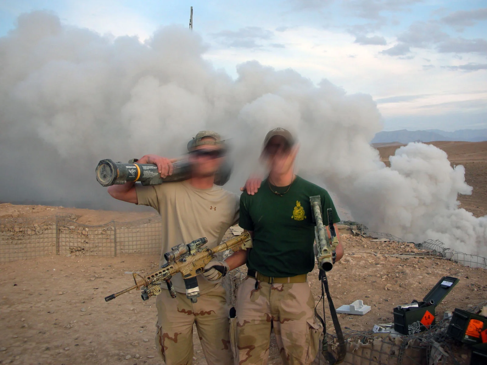 Two Dutch marines standing together after a live fire serial, smoke rising behind them