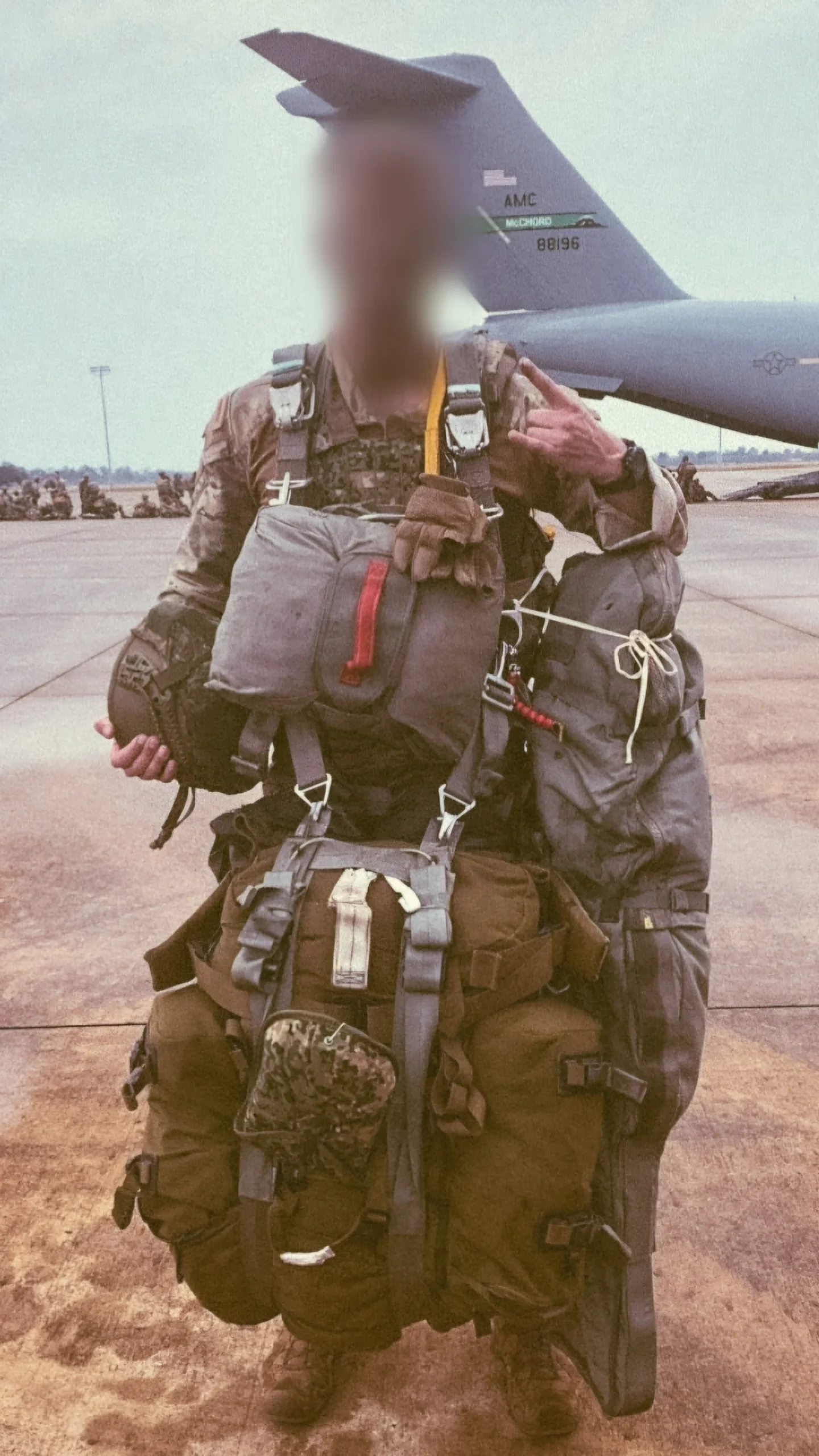 Dutch sniper carrying around 80 kilos of equipment before a static line jump, C-17 transport aircraft behind him