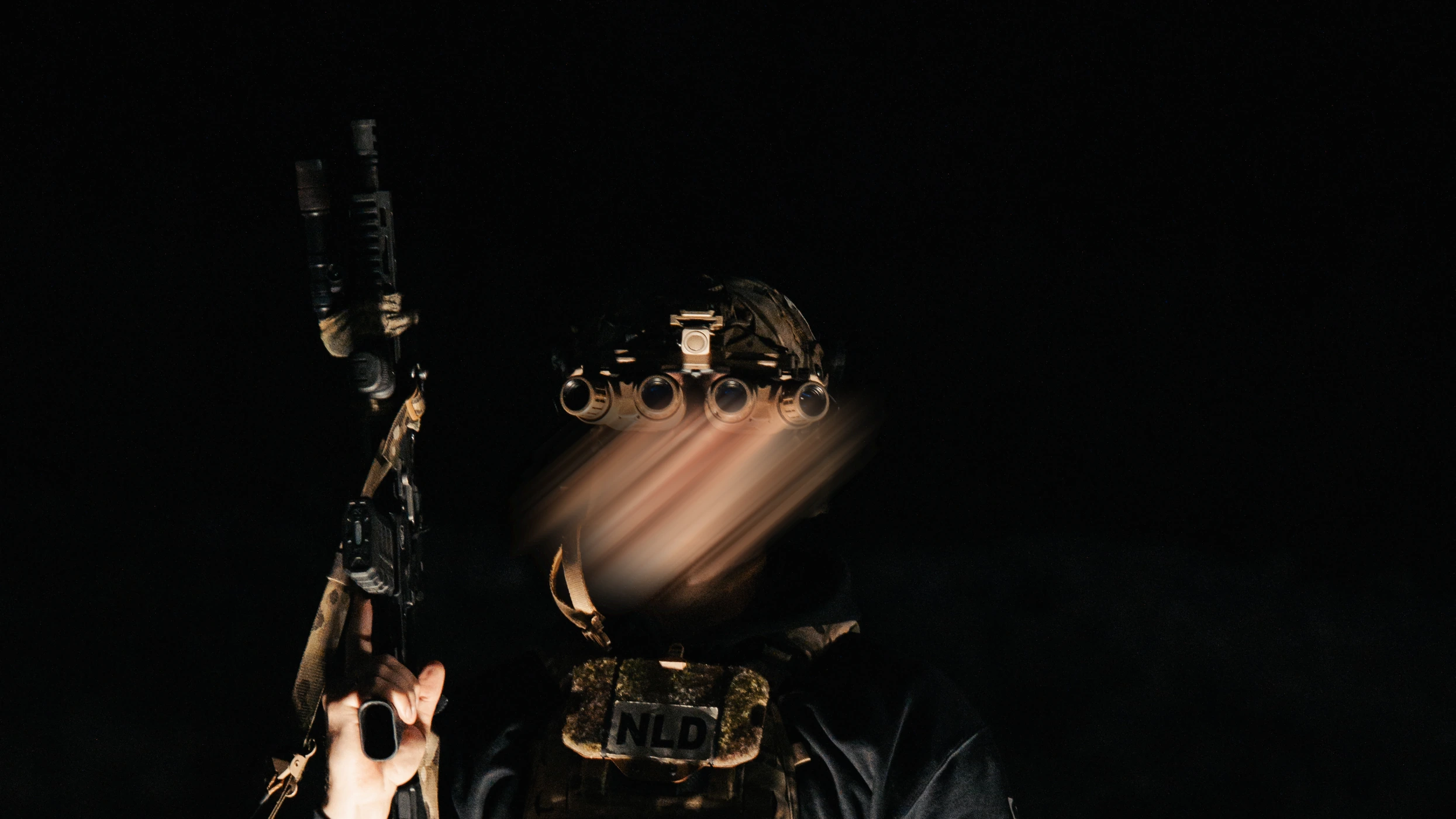 Operator with four tube night vision and NLD patch against a black background