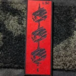 Tier 1 Controlled Chaos Patch in numbered black on red, leather patch close-up by The Trace