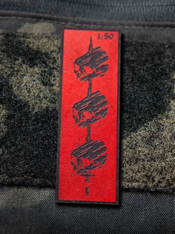 Tier 1 Controlled Chaos Patch in numbered black on red, leather patch close-up by The Trace