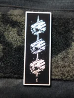 Tier 1 Controlled Chaos Patch in white on black, leather patch close-up by The Trace
